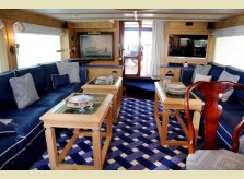 A Hallidays waxed pine panelled interior for a private yacht, with matching coffee tables - the tops inset with marine art